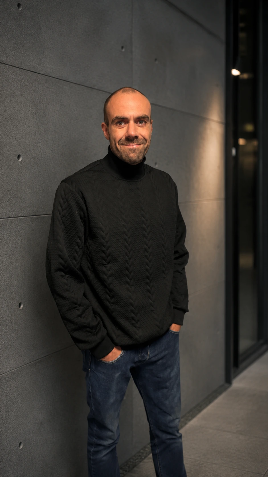 Kevin Bötger, Webdesigner für Coaches und Berater, vor einer Betonwand